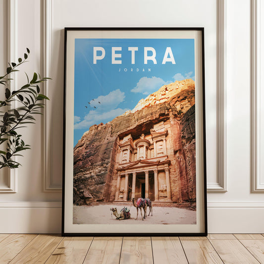 A framed poster of the ancient ruins of Petra, featuring the iconic Treasury of the Kings carved into a cliff face, with a camel and a person visible in the foreground.