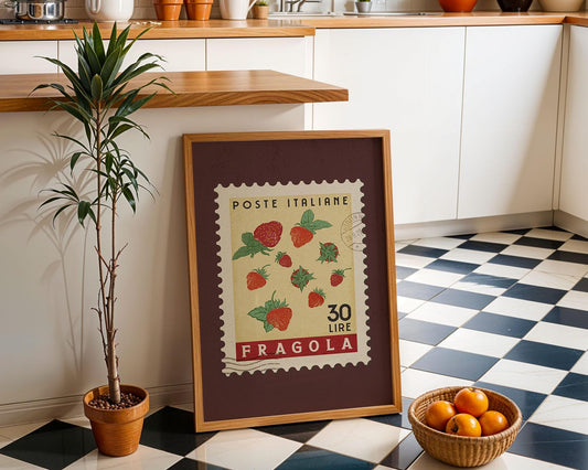a framed stamp with a strawberry design, placed on a checkered floor next to a potted plant and a basket of oranges.