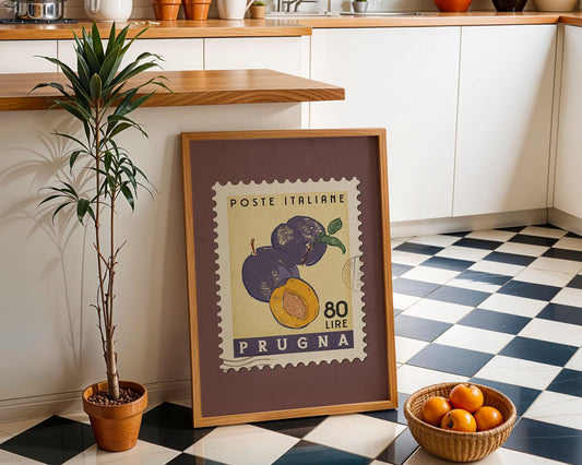 a framed stamp with a plum and an orange, placed on a checkered floor next to a potted plant and a basket of oranges.