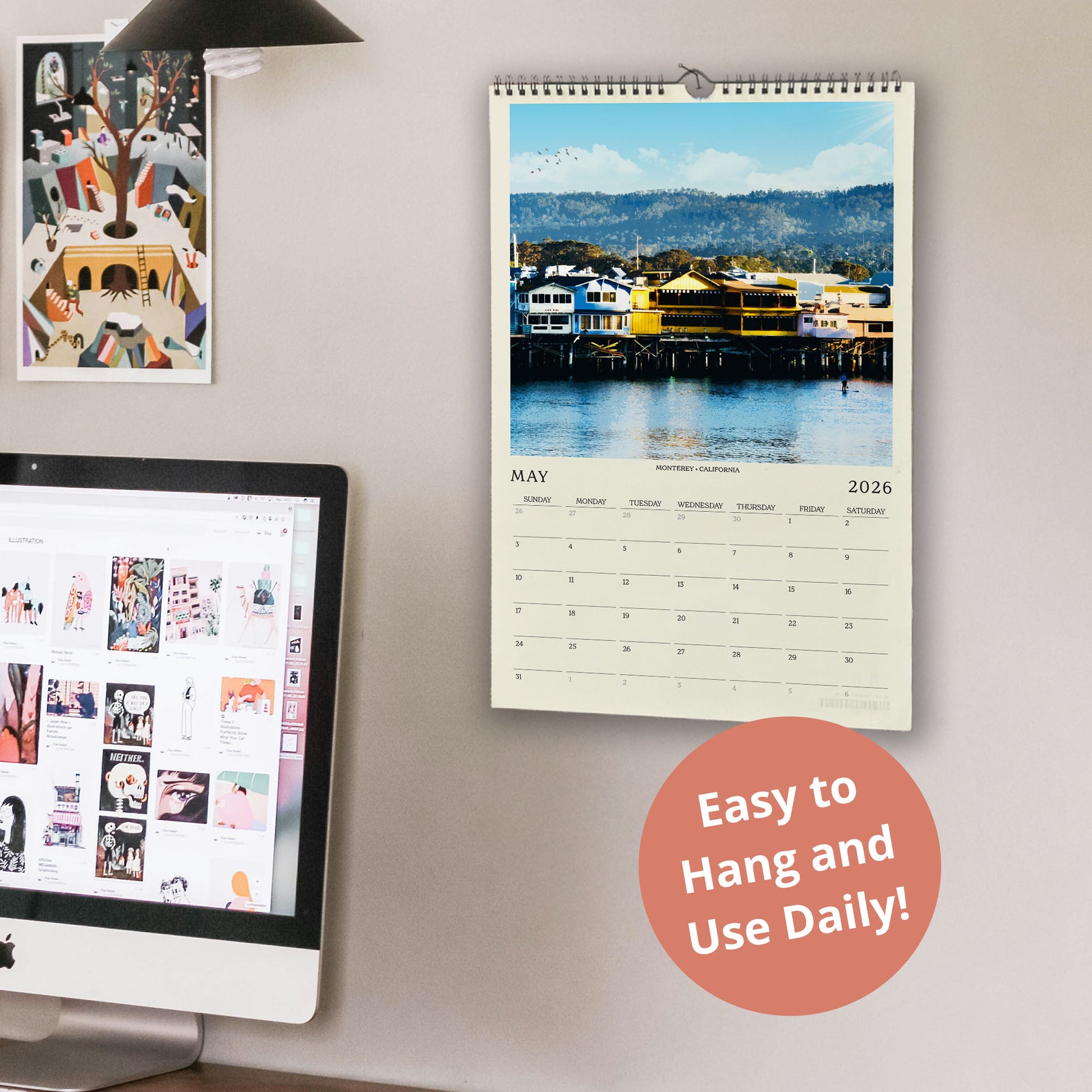 a wall with a calendar and a computer monitor, along with a few other items. The calendar displays a scenic image of a harbor with buildings and boats, and the computer monitor shows a webpage with various images. There is also a text overlay that reads "Easy to Hang and Use Daily!"
