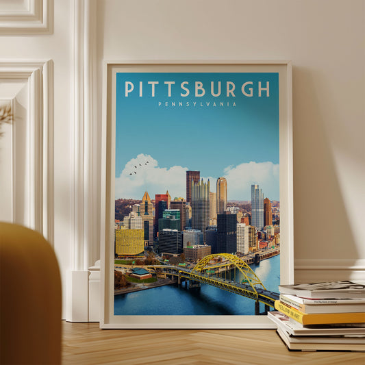 A framed poster of the Pittsburgh skyline, with the city's iconic landmarks and bridges visible, is displayed on a wall.