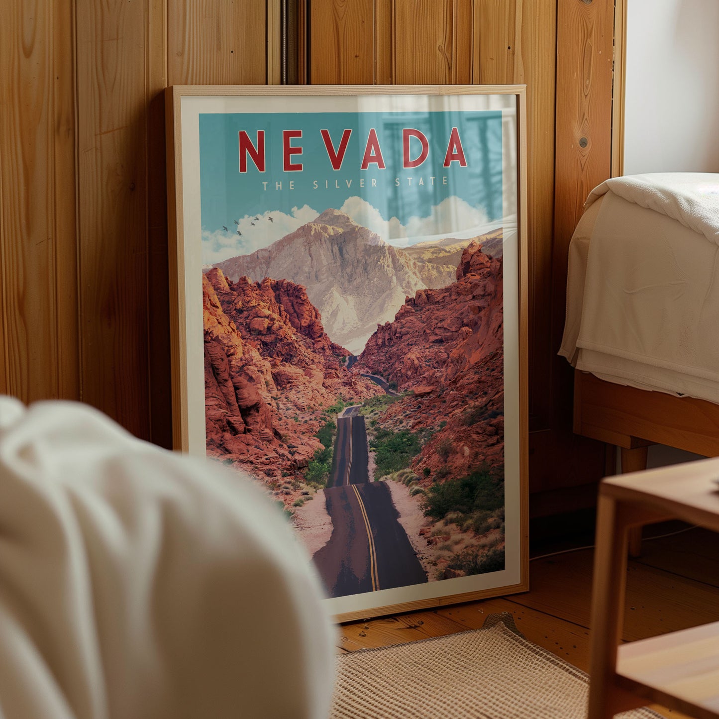 a framed poster of a scenic road winding through a mountainous landscape, with the text "NEVADA" prominently displayed.