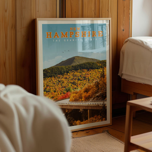 A framed poster of a scenic autumn landscape in New Hampshire, with a mountain and forest in the background.