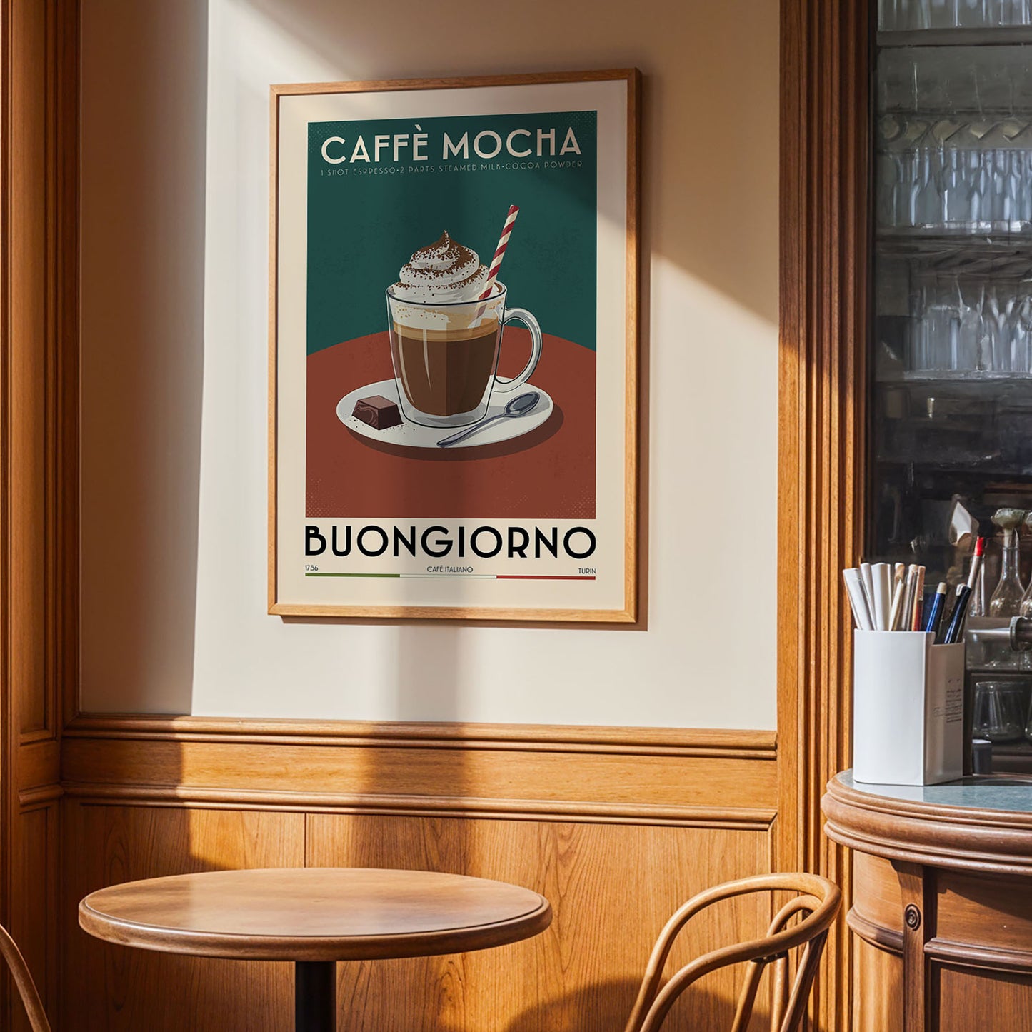 a framed poster of a coffee mug with a whipped cream topping, hanging on a wall in a cafe or restaurant setting.