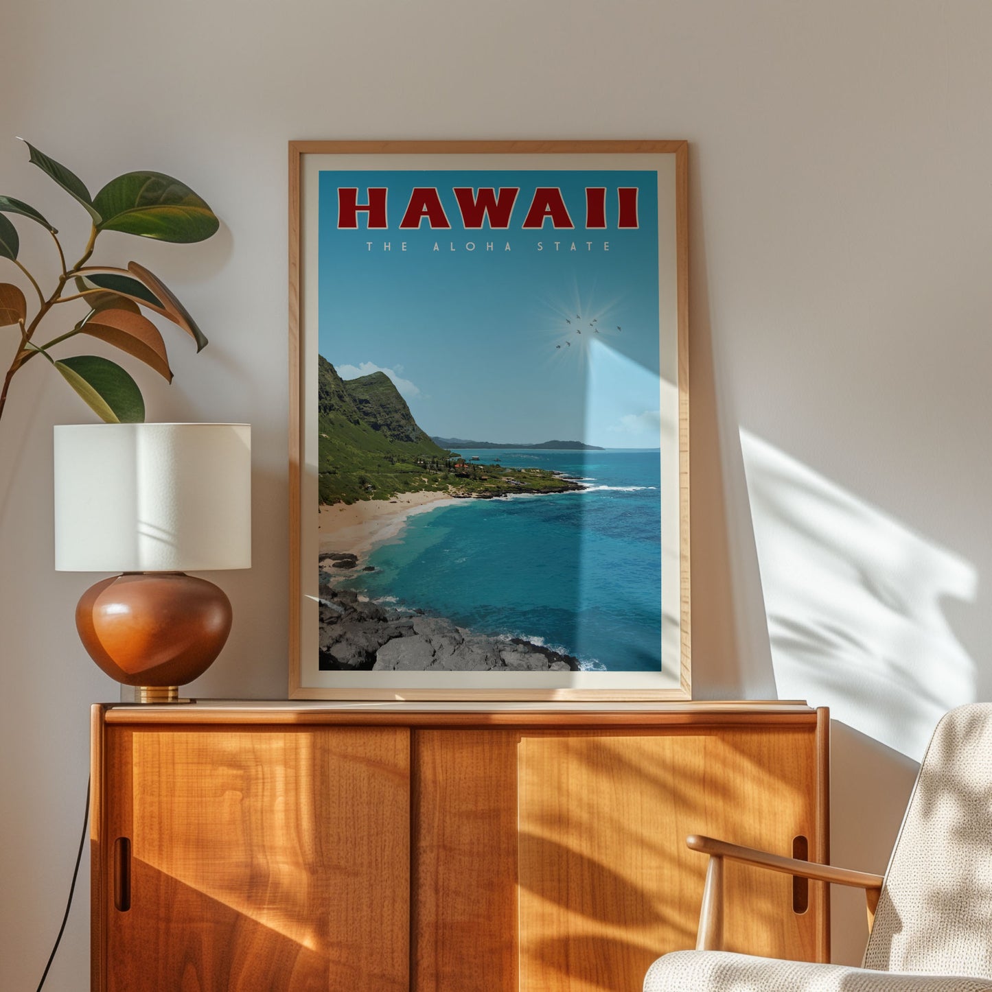 A framed poster of a beach scene in Hawaii hangs on a wall, with a lamp and a plant to the left of the frame.