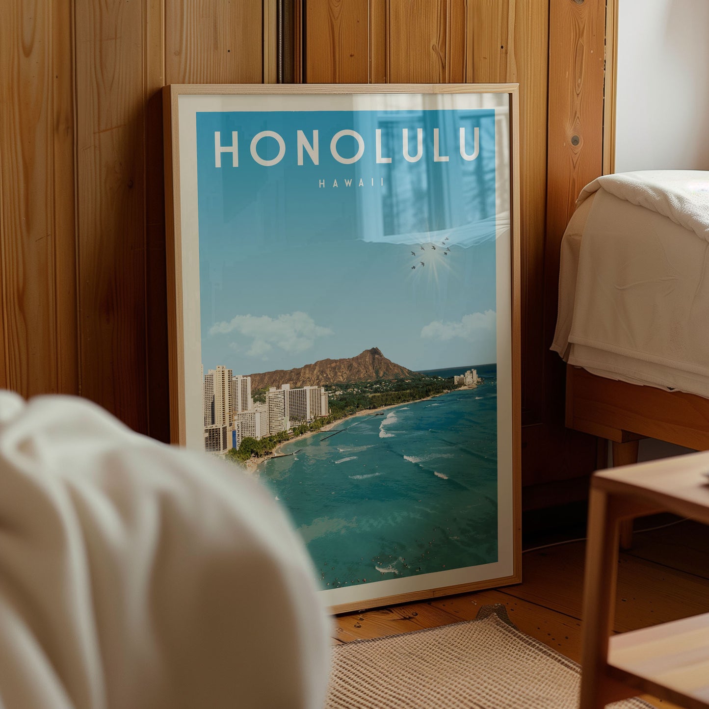 A framed poster of Honolulu, Hawaii, with a view of the ocean and city skyline, is displayed in a room with a wooden wall.