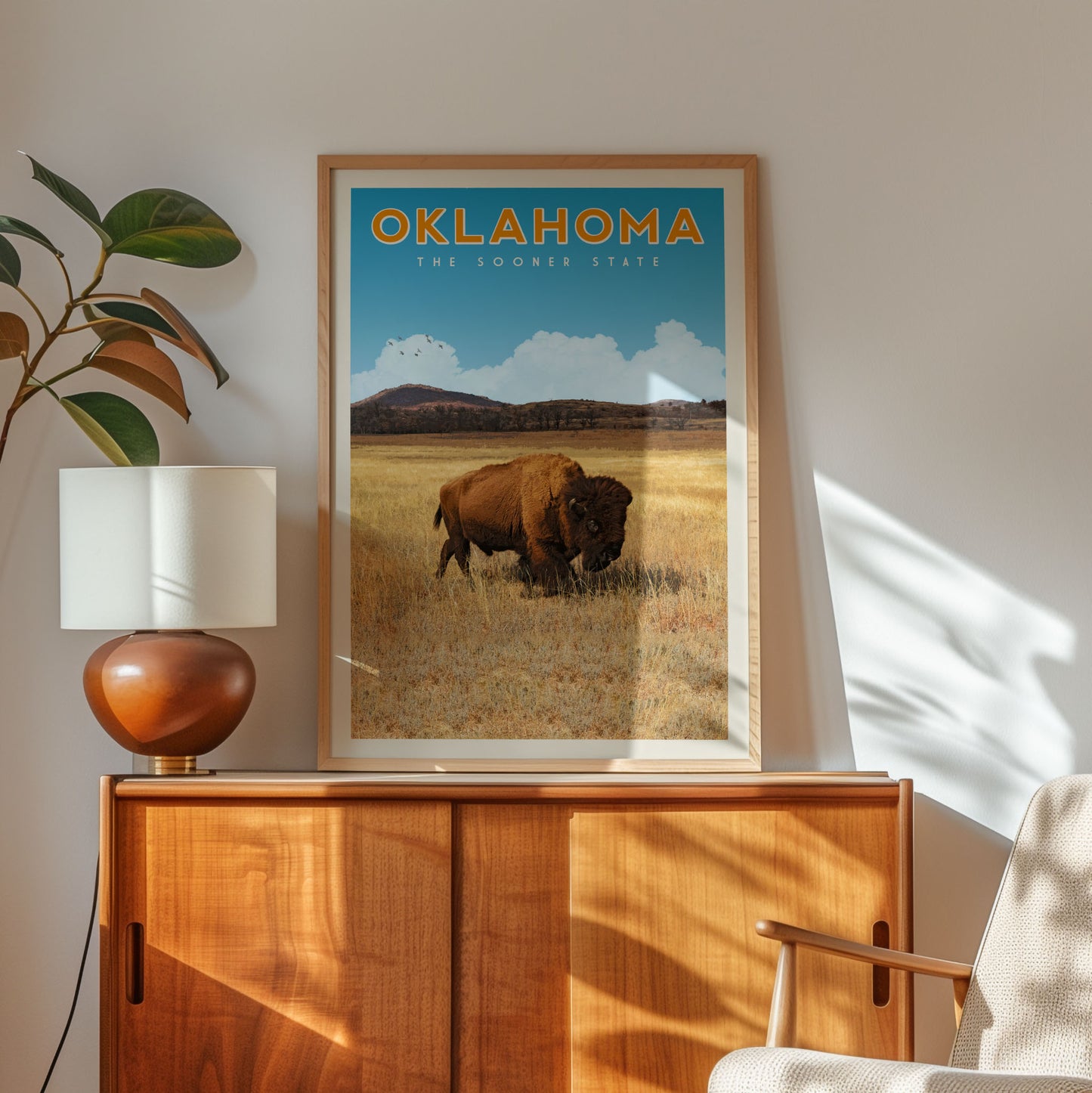 a framed poster of a buffalo in a field, with the text "OKLAHOMA THE SOONER STATE" written above it.