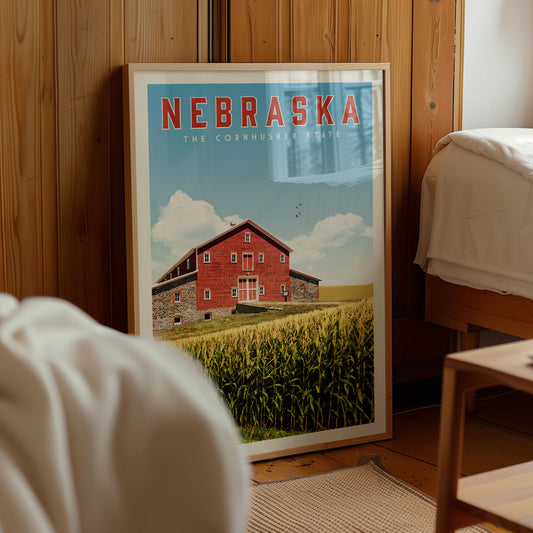 A framed poster of a red barn with a field of corn in the background, located in a room with wooden walls.