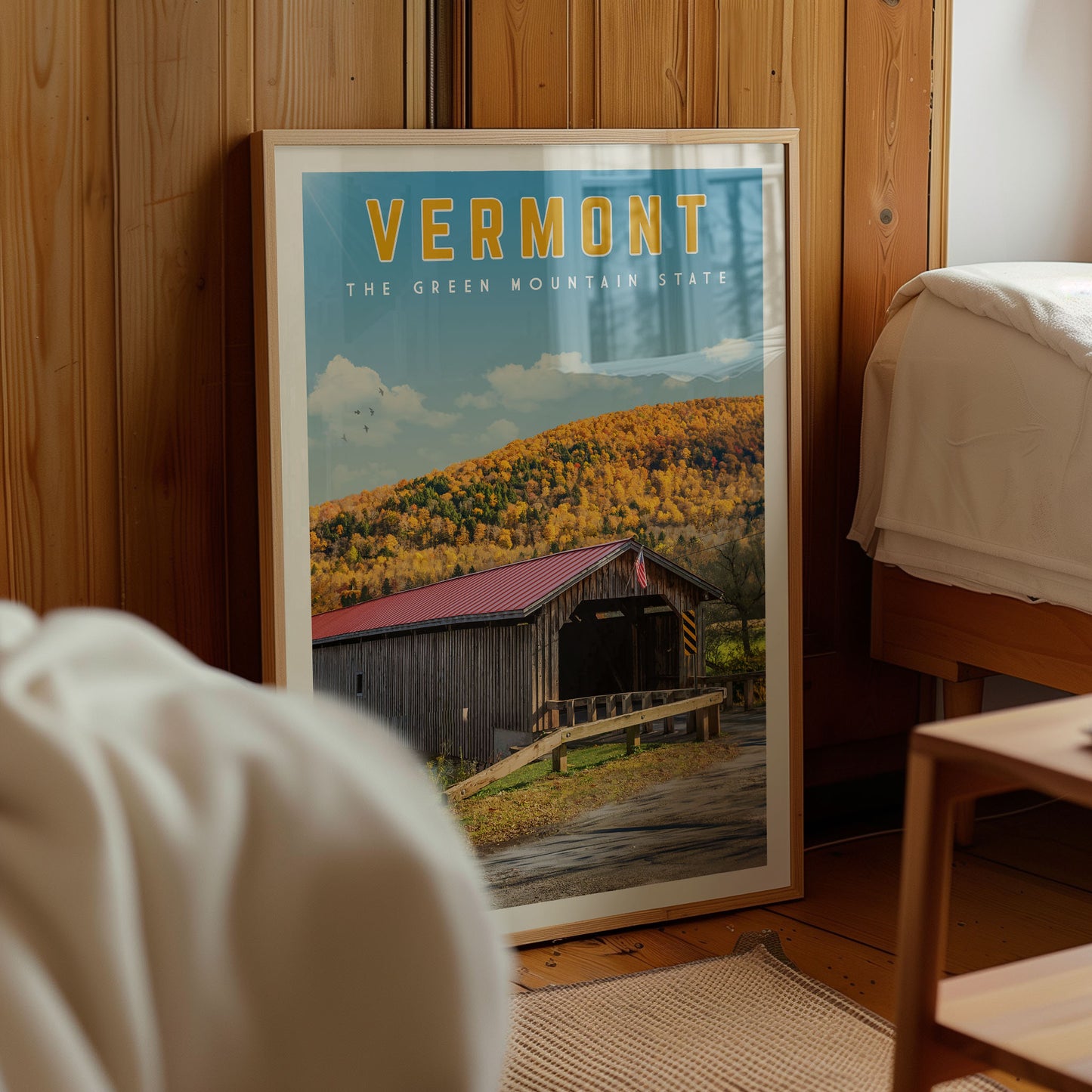 a framed poster of a wooden cabin with a scenic mountain landscape in the background, located in Vermont, the green mountain state.