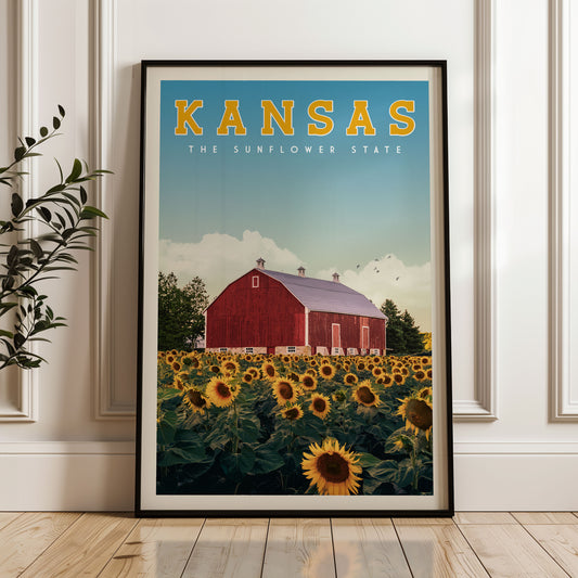 A framed poster of a red barn surrounded by a field of sunflowers, with the text "KANSAS THE SUNFLOWER STATE" prominently displayed.
