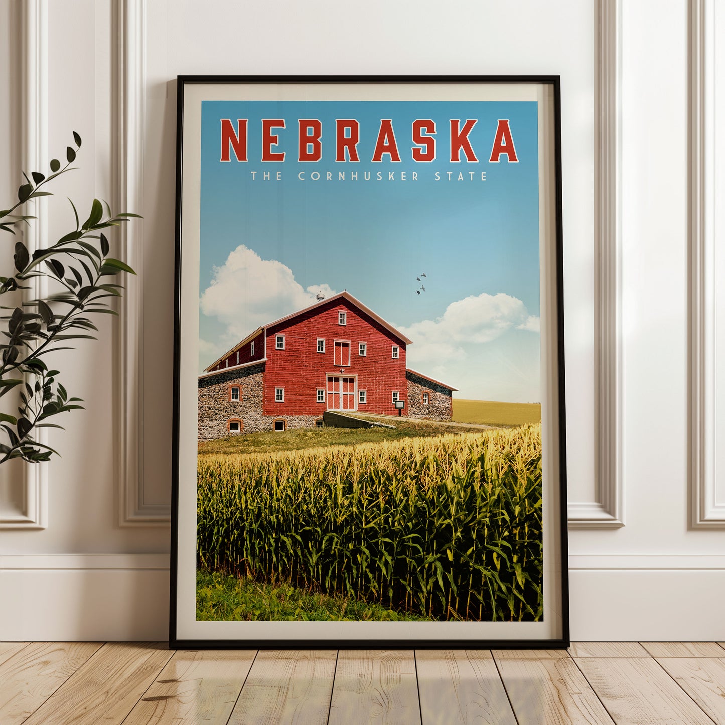 A framed poster of a red barn in the cornfield of Nebraska, with the text "NEBRASKA THE CORNHUSKER STATE" prominently displayed.