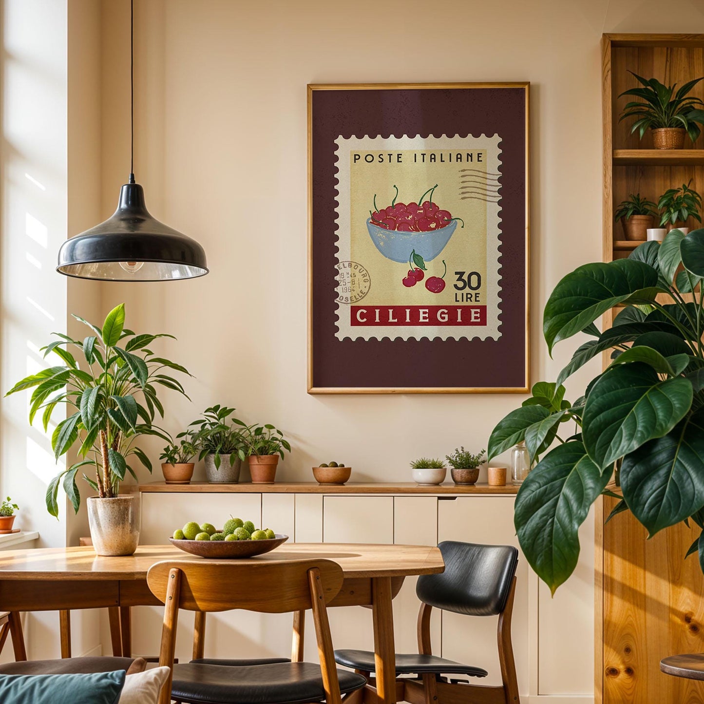 a cozy dining area with a wooden table, chairs, and a potted plant. A framed stamp-like artwork hangs on the wall, featuring a bowl of cherries and the text "POSTE ITALIENE 30 LIME CILIEGIE".