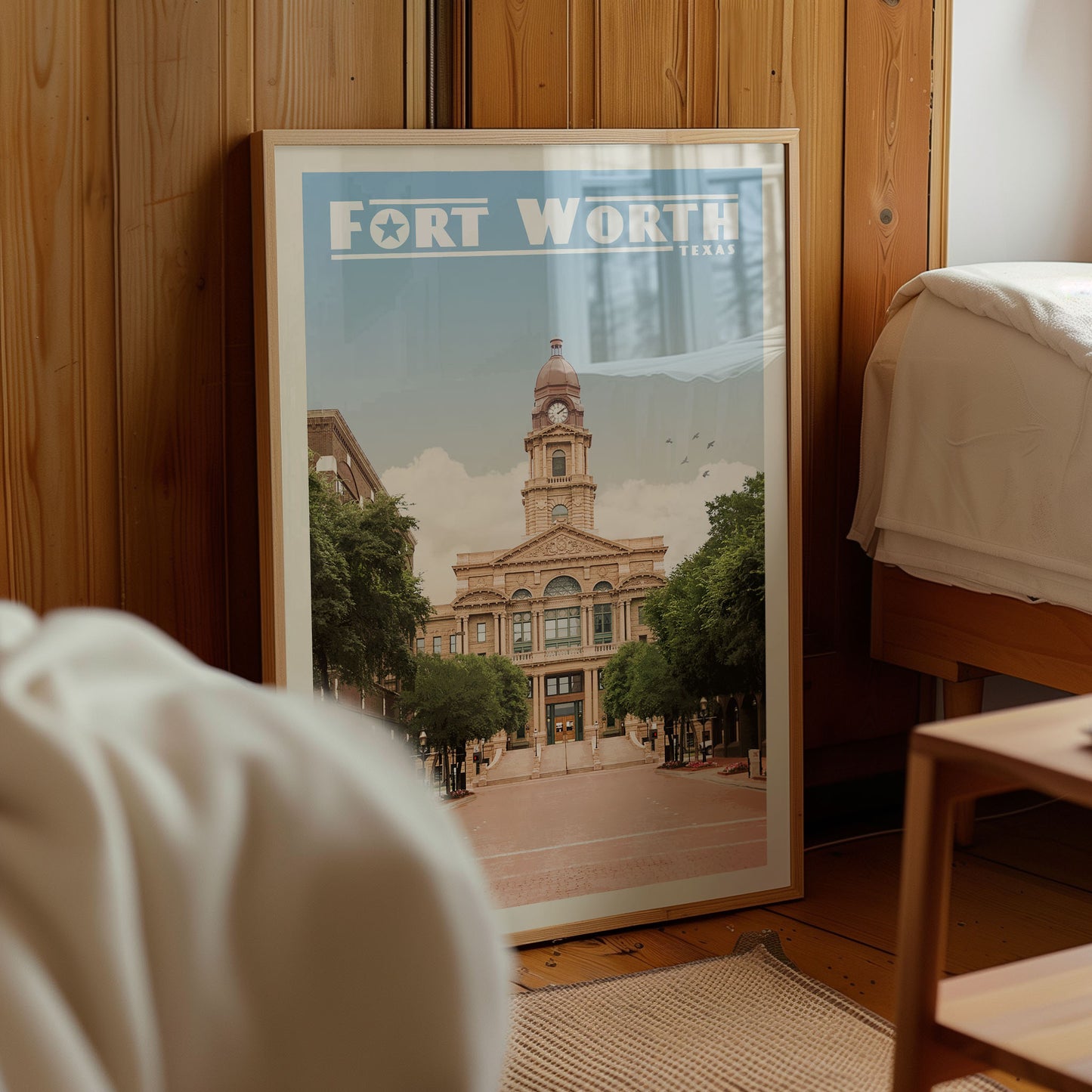 A framed poster of Fort Worth, Texas, featuring a large building with a clock tower and surrounded by trees.