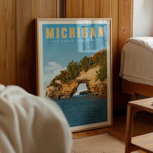 A framed poster of a scenic lake landscape with a large arch formation, displayed in a room with wooden walls.