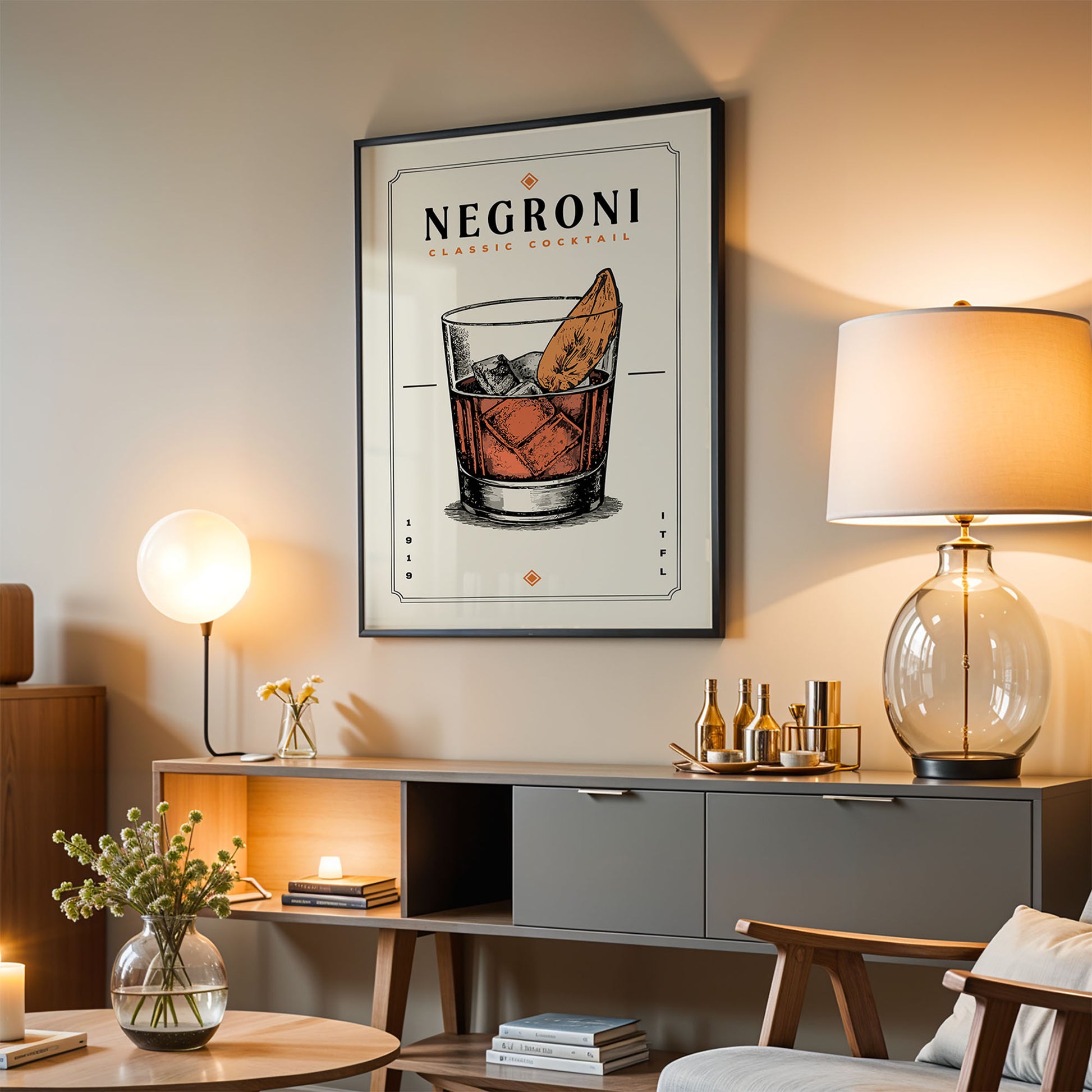 a living room with a framed poster of a cocktail glass and a cocktail on the wall, a wooden cabinet, a lamp, and a vase with flowers.