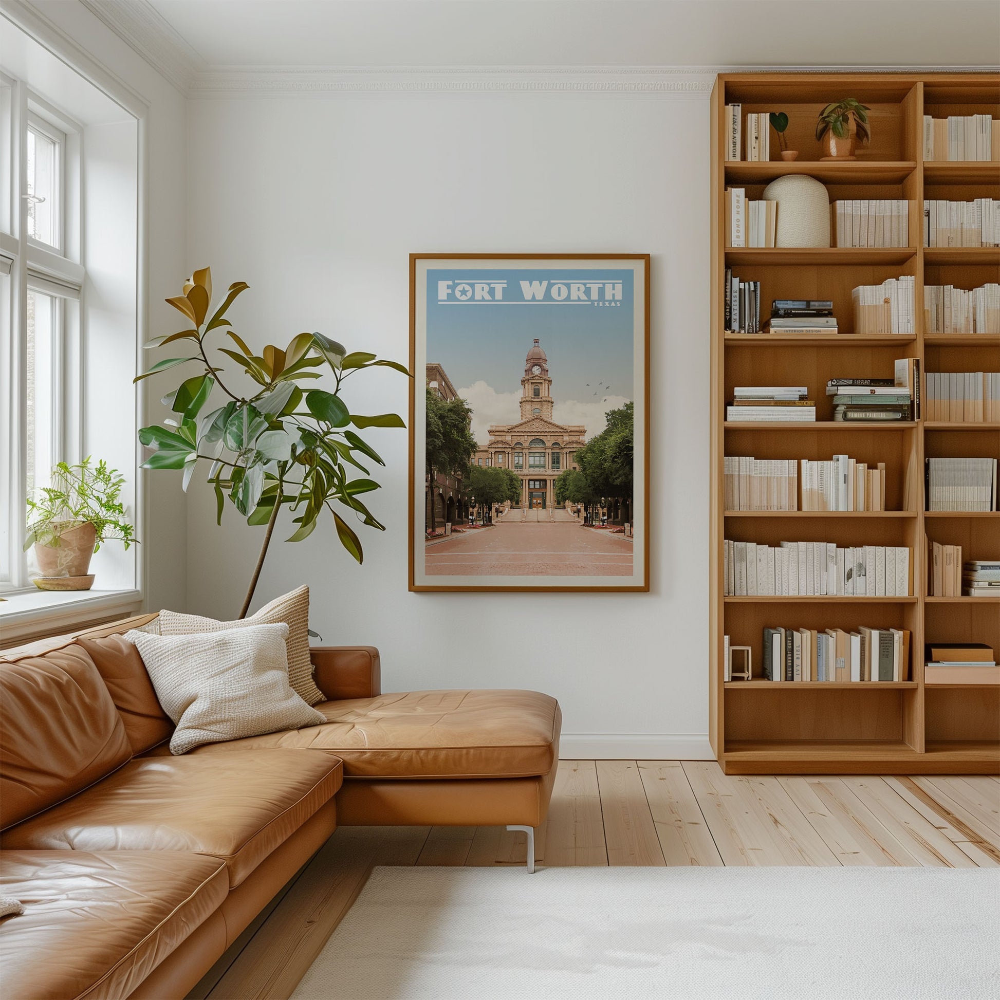 a cozy living room with a large bookshelf filled with books, a comfortable leather couch, and a framed poster of Fort Worth, Texas, hanging on the wall.