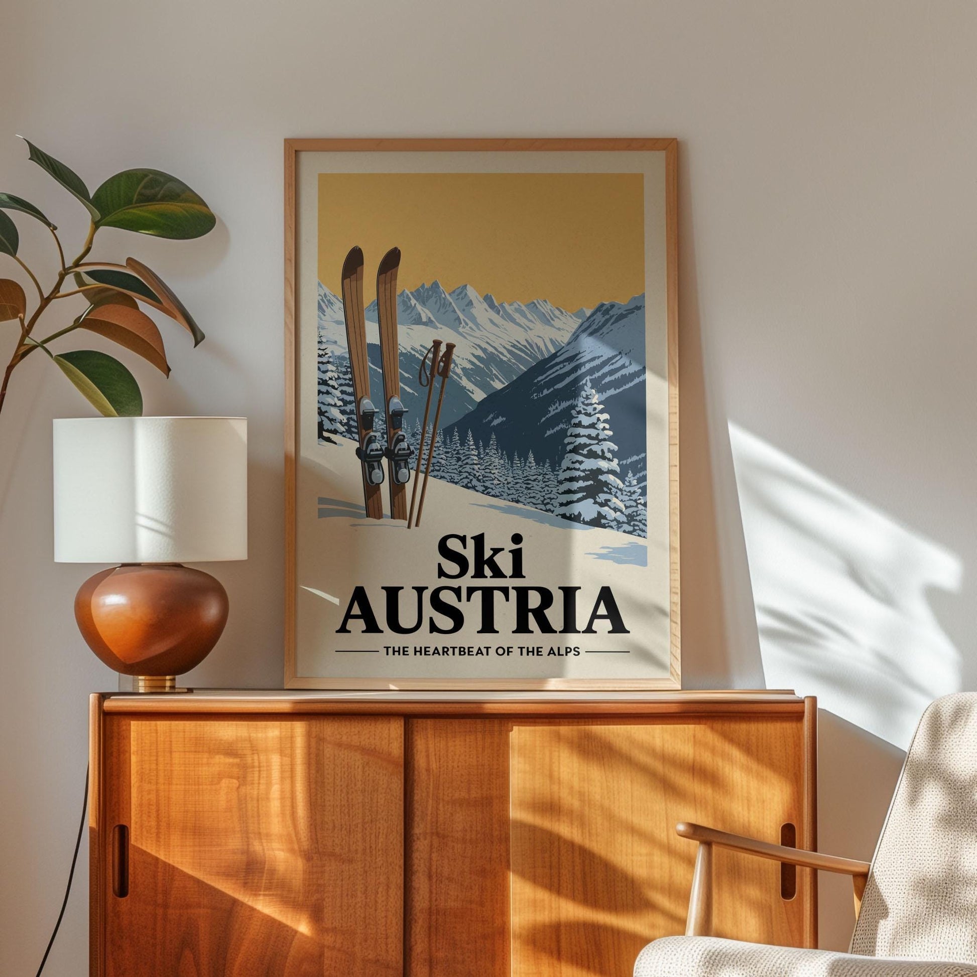 A framed poster of a snowy mountain landscape with skis, hanging on a wall above a wooden cabinet.