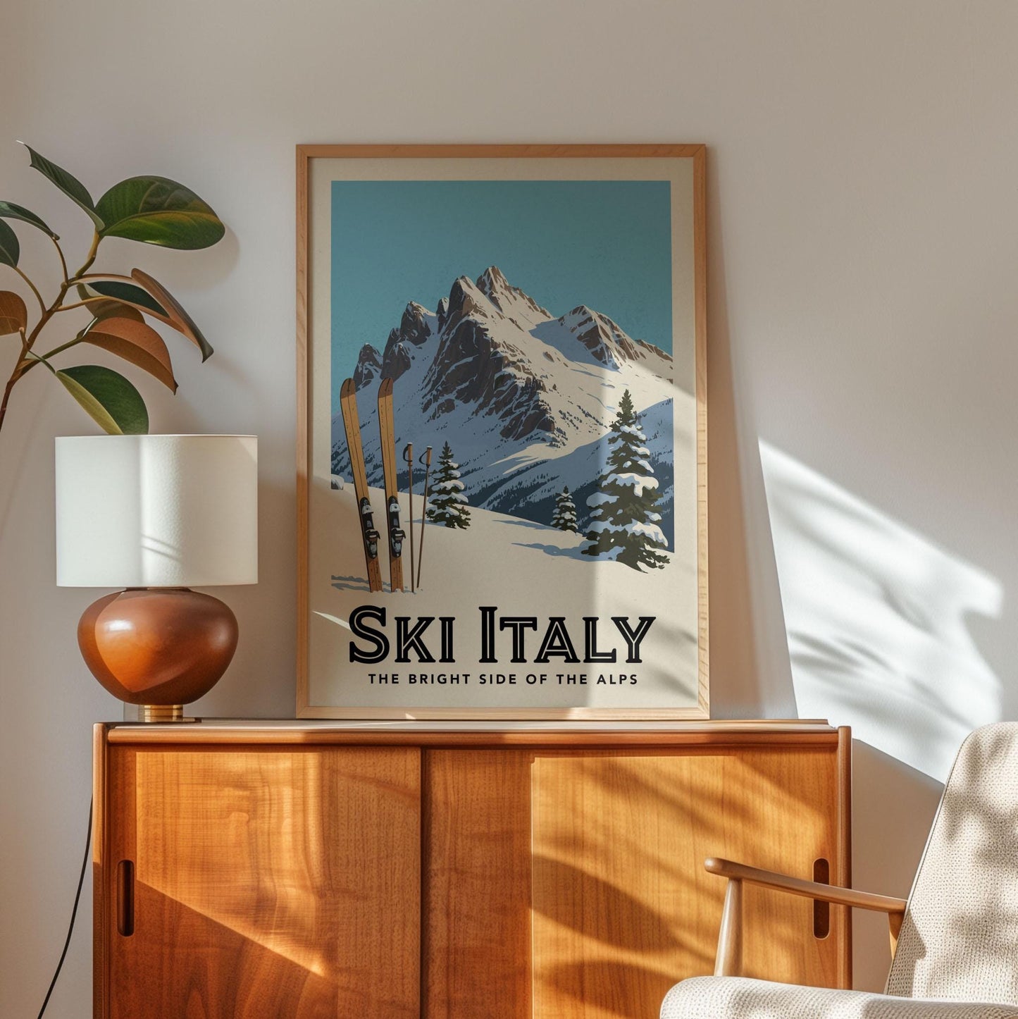 A framed poster of a snowy mountain landscape with skis, hanging on a wall above a wooden cabinet.