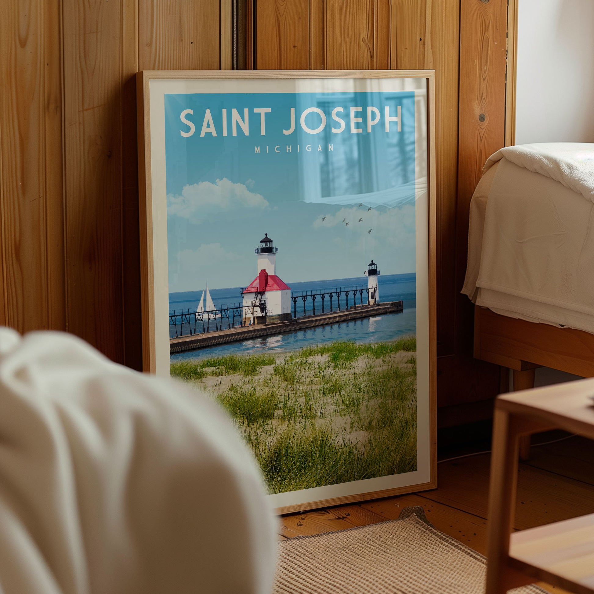 A framed poster of a lighthouse and a body of water, with the text "SAINT JOSEPH MICHIGAN" prominently displayed.