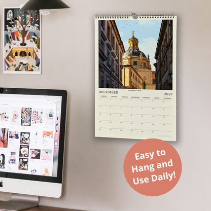 a wall calendar with a photo of a city street and buildings, as well as a computer monitor displaying a webpage. The calendar is hanging on a wall, and there is a text overlay that reads "Easy to Hang and Use Daily!"