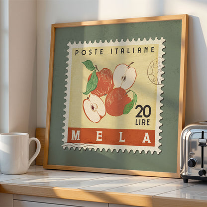a framed stamp-like artwork depicting a scene with apples, placed on a kitchen counter next to a toaster.
