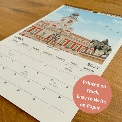 A wall calendar with a photo of a building and a statue on the cover, and a text overlay stating that the calendar is printed on thick paper and easy to write on paper.