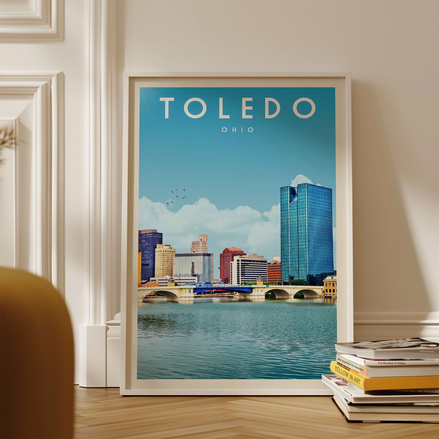 A framed poster of the city of Toledo, Ohio, featuring a skyline with tall buildings and a river in the foreground.