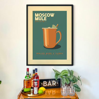 a framed poster of a Moscow Mule cocktail hanging on a wall above a wooden bar counter with various liquor bottles and glasses.