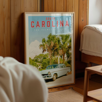 A framed poster of a car in a tropical setting, with palm trees and a house in the background, is displayed in a room with wooden walls.