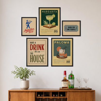 a wall display with framed vintage-style advertisements for margaritas and tequila, along with a wooden cabinet with a plant and bottles of alcohol.