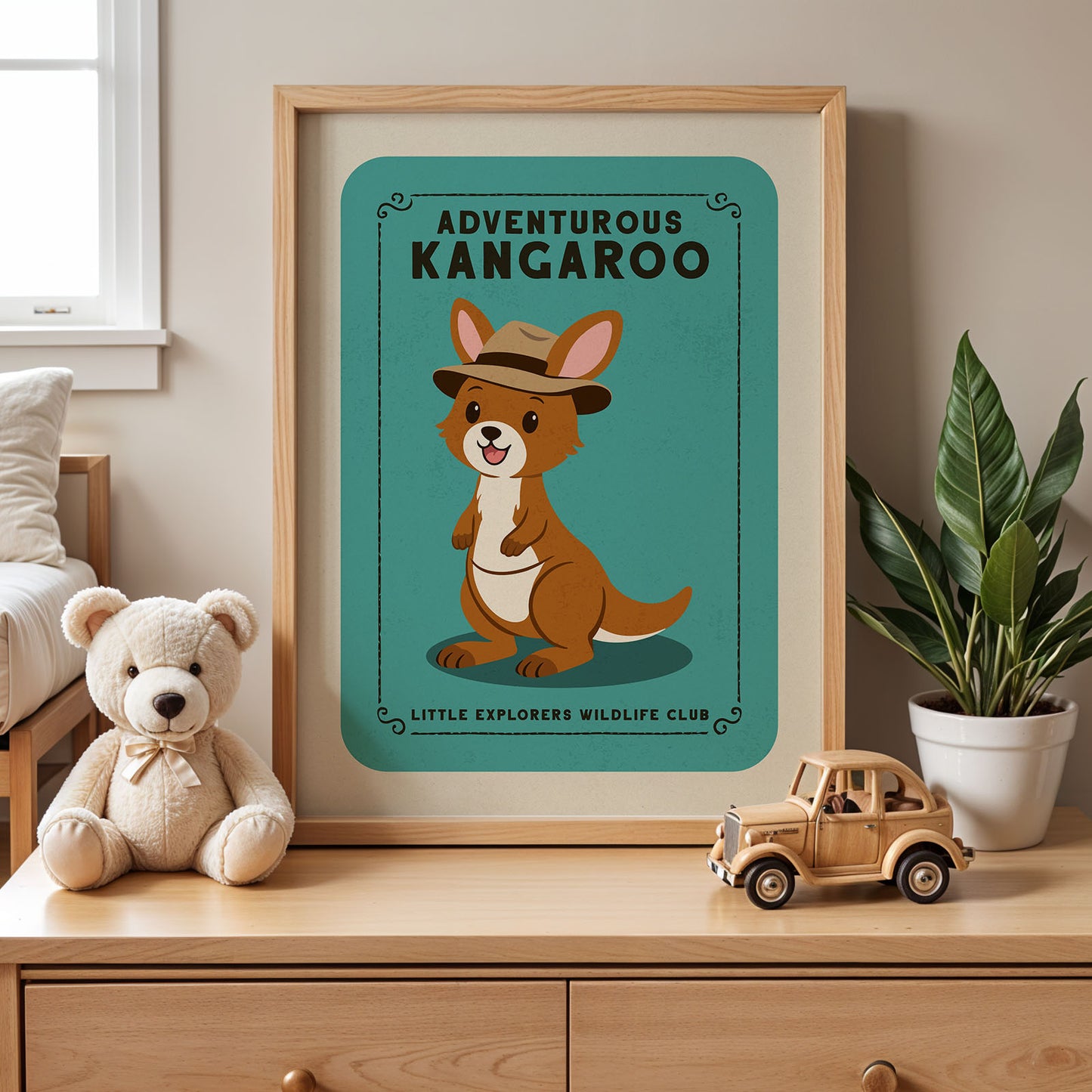 a framed poster of a kangaroo wearing a hat, placed on a wooden dresser next to a stuffed teddy bear and a toy truck.
