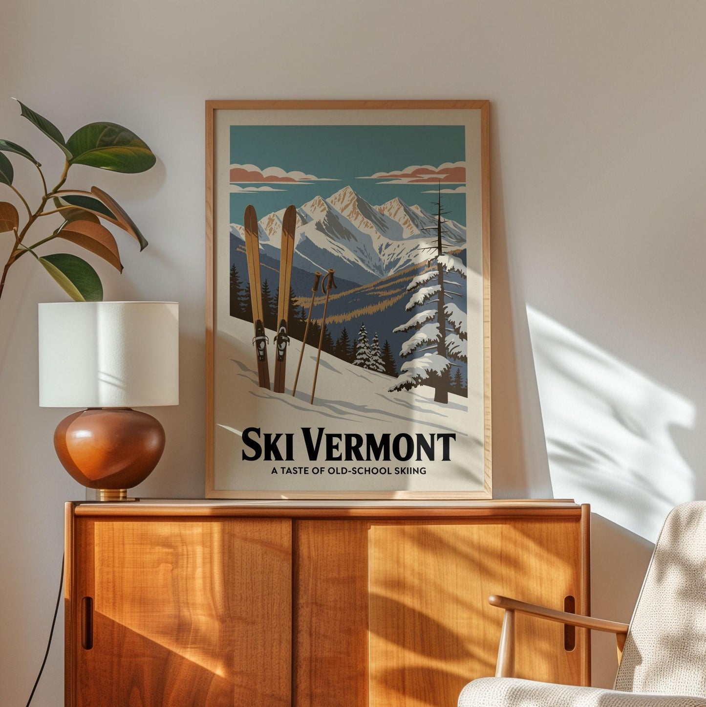 A framed poster of a snowy mountain landscape with skis is displayed on a wooden cabinet, accompanied by a lamp and a plant in the corner of the room.