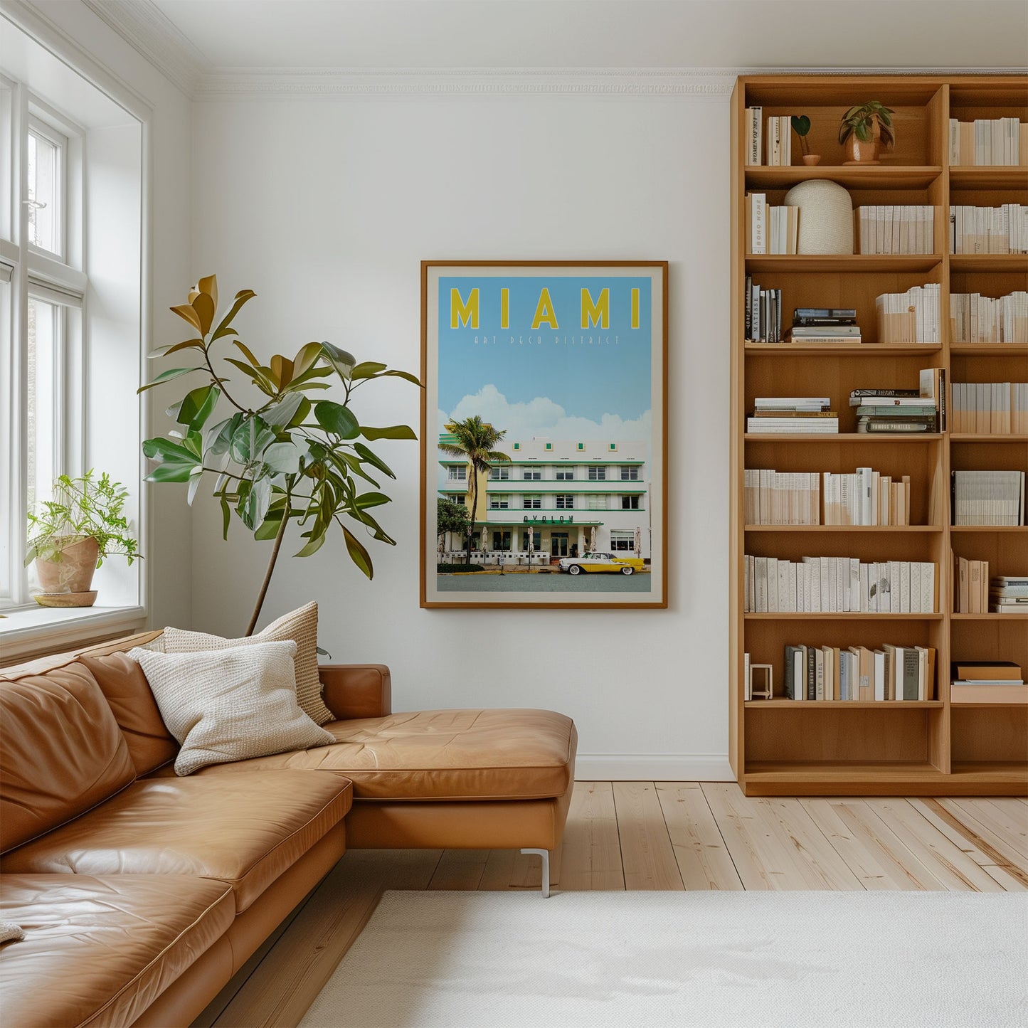 a cozy living room with a large window, a comfortable leather couch, a bookshelf filled with books, and a framed poster of a beach resort in Miami.