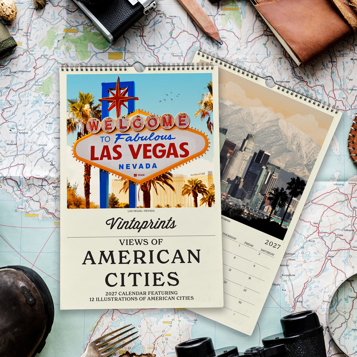 a calendar with a vibrant image of the Las Vegas Strip and the iconic sign, surrounded by various travel-related items such as a map, a camera, and a pair of binoculars.