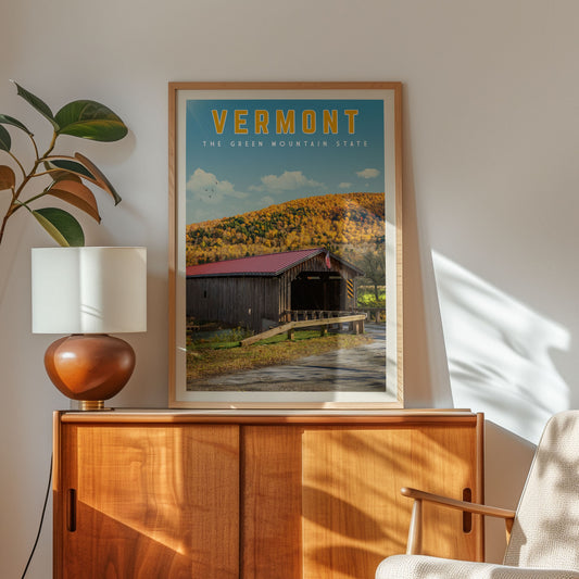 a framed poster of a wooden cabin with a red roof, set against a backdrop of a mountain and trees, hanging on a wall.