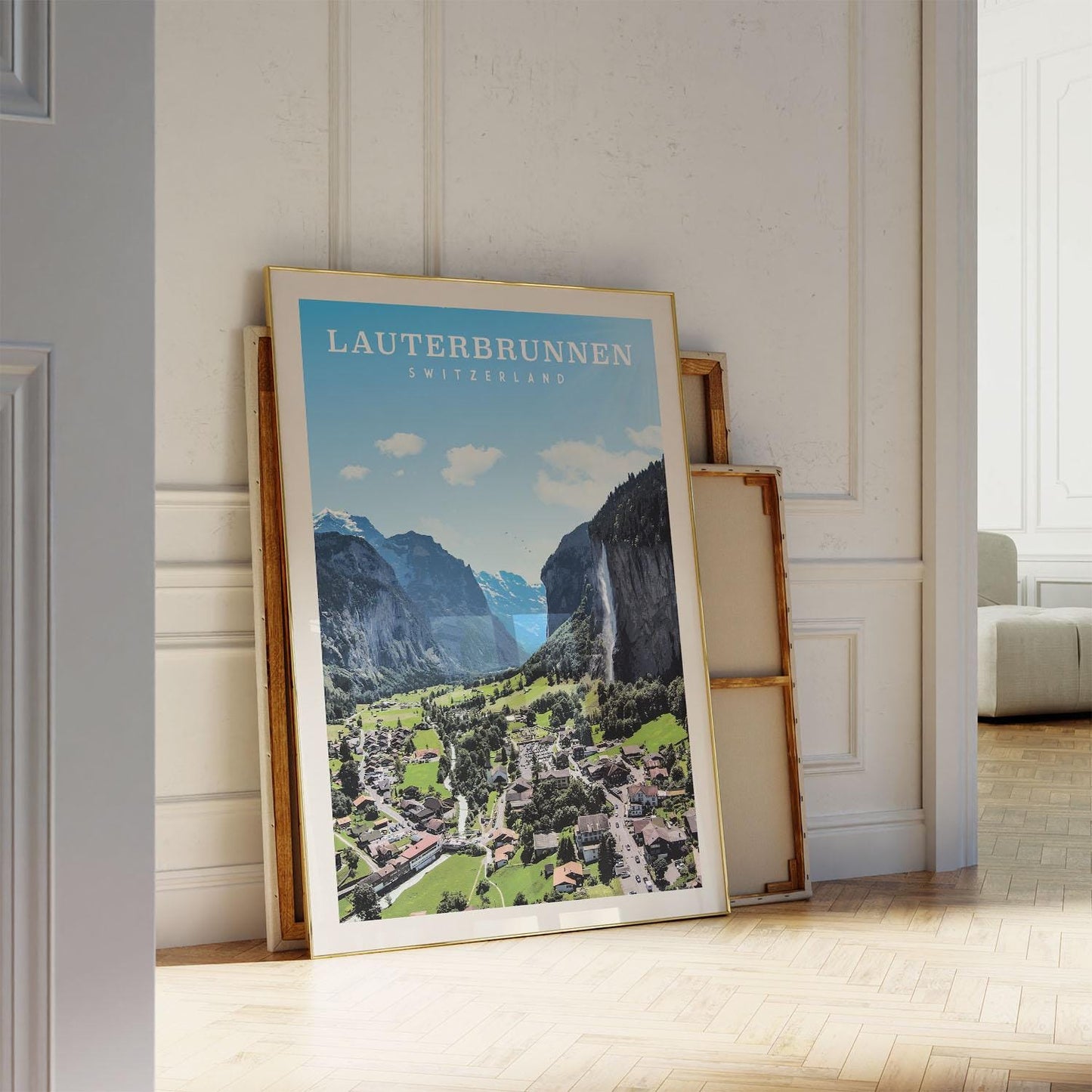 A framed poster of the Lauterbrunnen valley in Switzerland, featuring a scenic mountain landscape with a town nestled in the valley below.