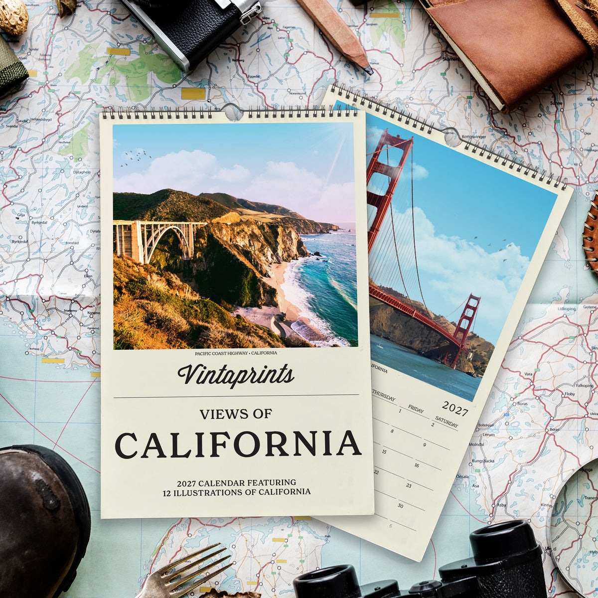 a calendar with a scenic view of California, including a bridge and a mountain, surrounded by various travel-related items such as a map, a camera, and a pair of binoculars.