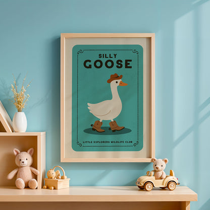 a framed poster of a cartoon goose wearing a cowboy hat, with the title "Silly Goose" and the text "Little Explorers Wildlife Club" below it. The poster is displayed on a blue wall above a wooden shelf with various toys, including a teddy bear and a toy car.