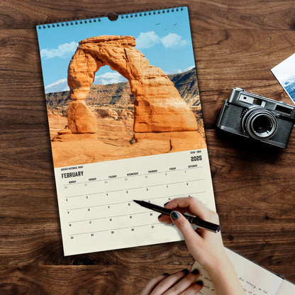 a calendar with a hand holding a pen and a camera