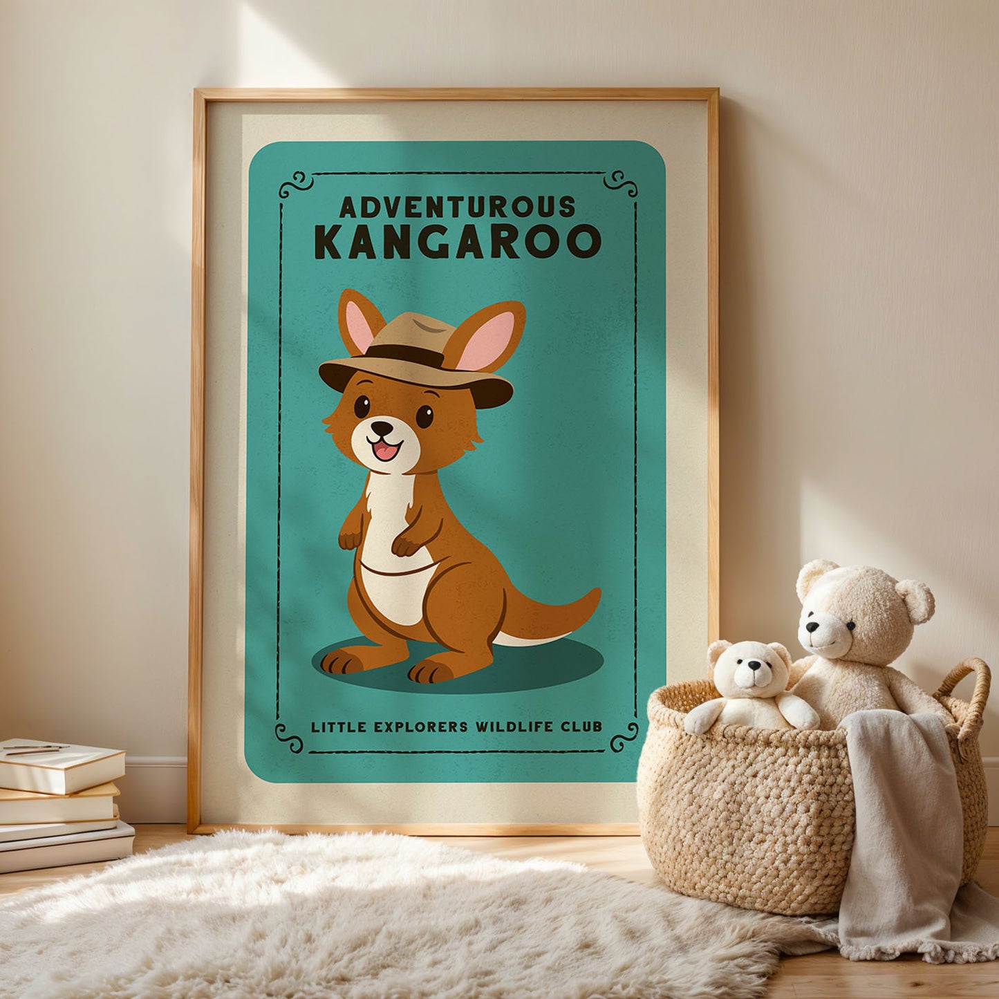 a framed poster of a kangaroo wearing a hat, with the text "Adventurous Kangaroo" and "Little Explorers Wildlife Club" below it. Next to the poster, there is a woven basket containing two stuffed animals, and a stack of books is also visible in the background.