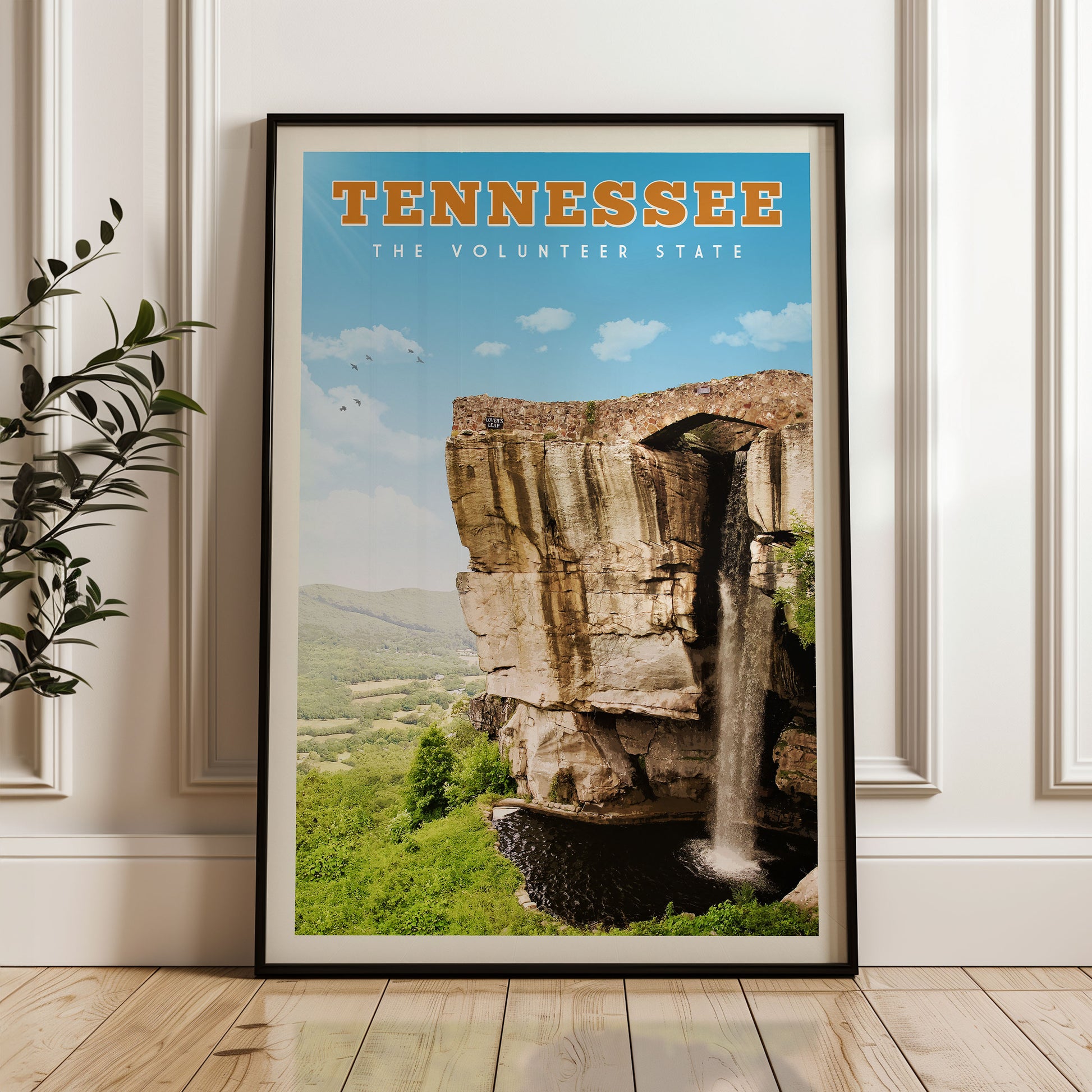 A framed poster of a waterfall in Tennessee, with the text "TENNESSEE THE VOLUNTEER STATE" prominently displayed.