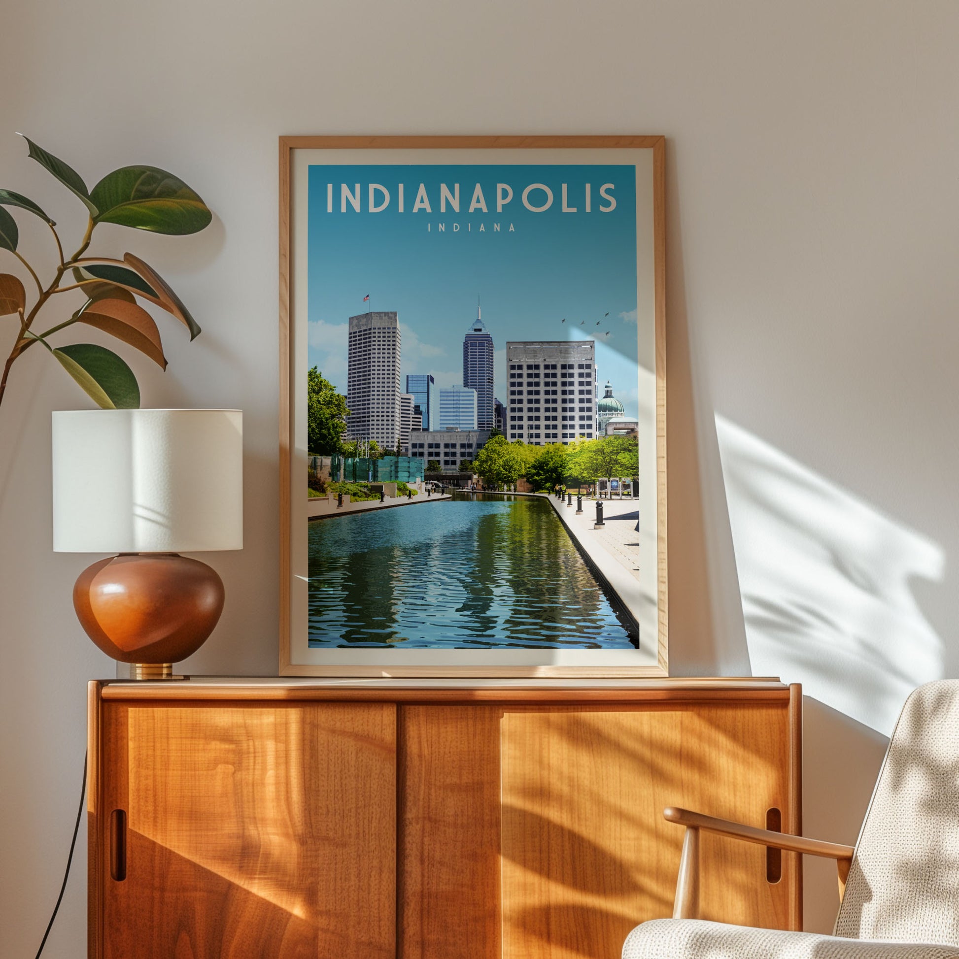 a framed poster of the Indianapolis skyline, with a cityscape of tall buildings and a large body of water in the foreground.