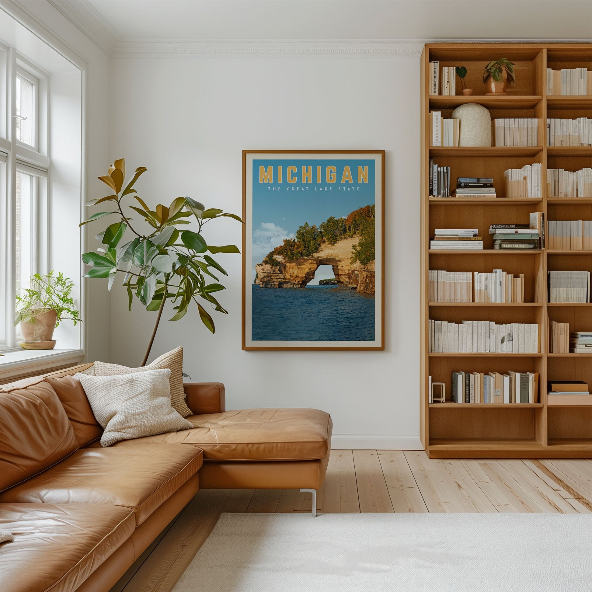 a cozy living room with a large bookshelf filled with books, a comfortable leather couch, and a framed poster of a scenic lake view on the wall.