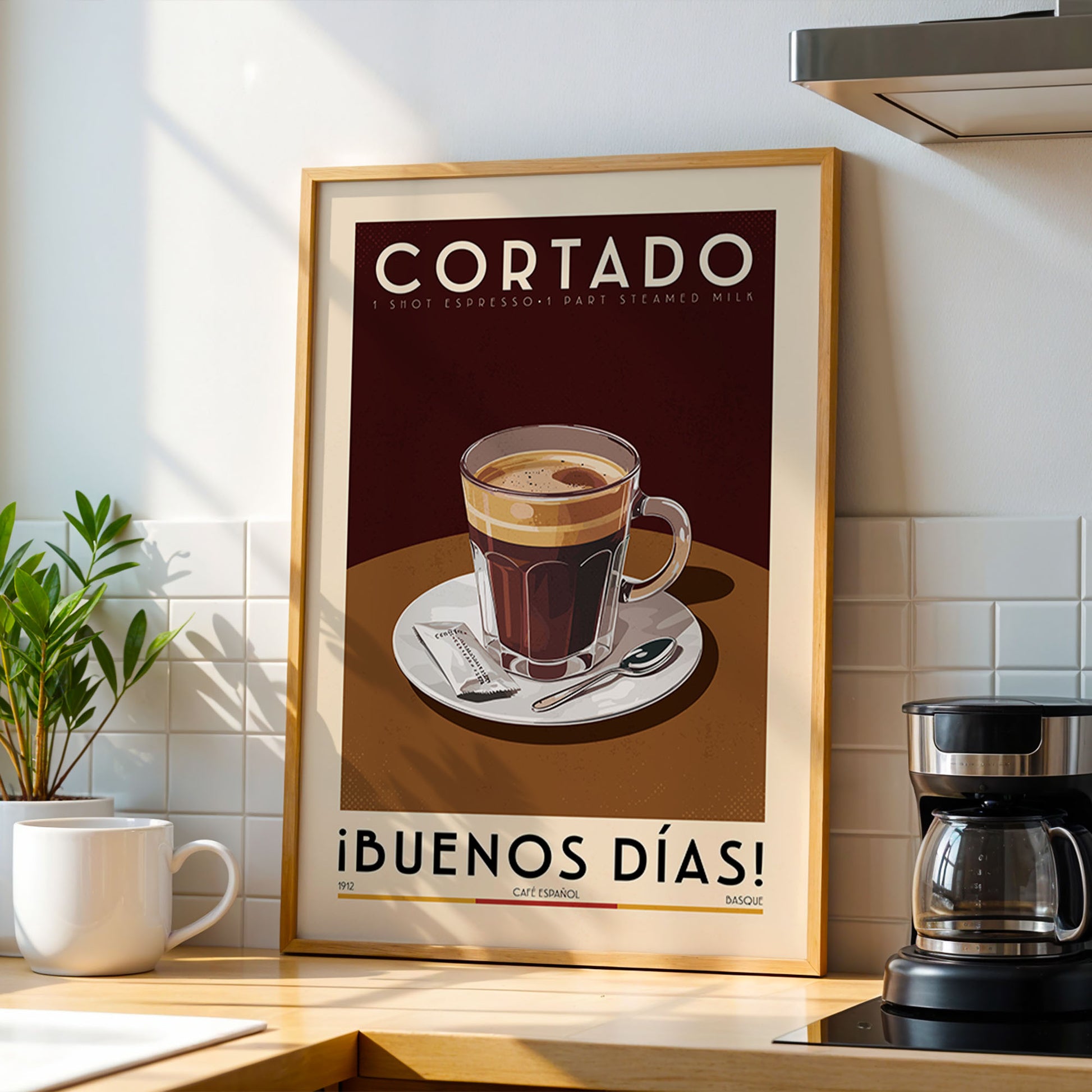 a framed poster of a coffee cup on a table, with the text "CORTADO 1 shot espresso-dart steamed milk" and "iBUENOS DÍAS!" (which translates to "Good morning!") written on it.