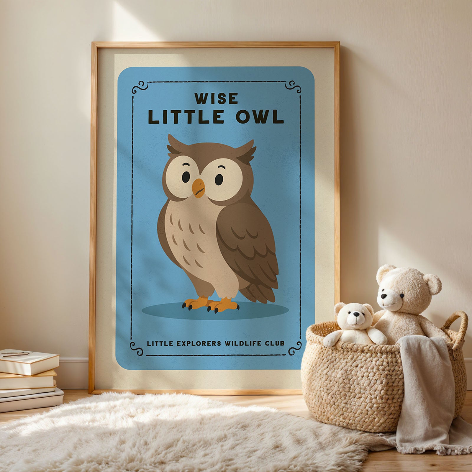 a framed poster of an owl with the text "WISE LITTLE OWL" and "LITTLE EXPLORERS WILDLIFE CLUB" below it, along with a basket containing two teddy bears.