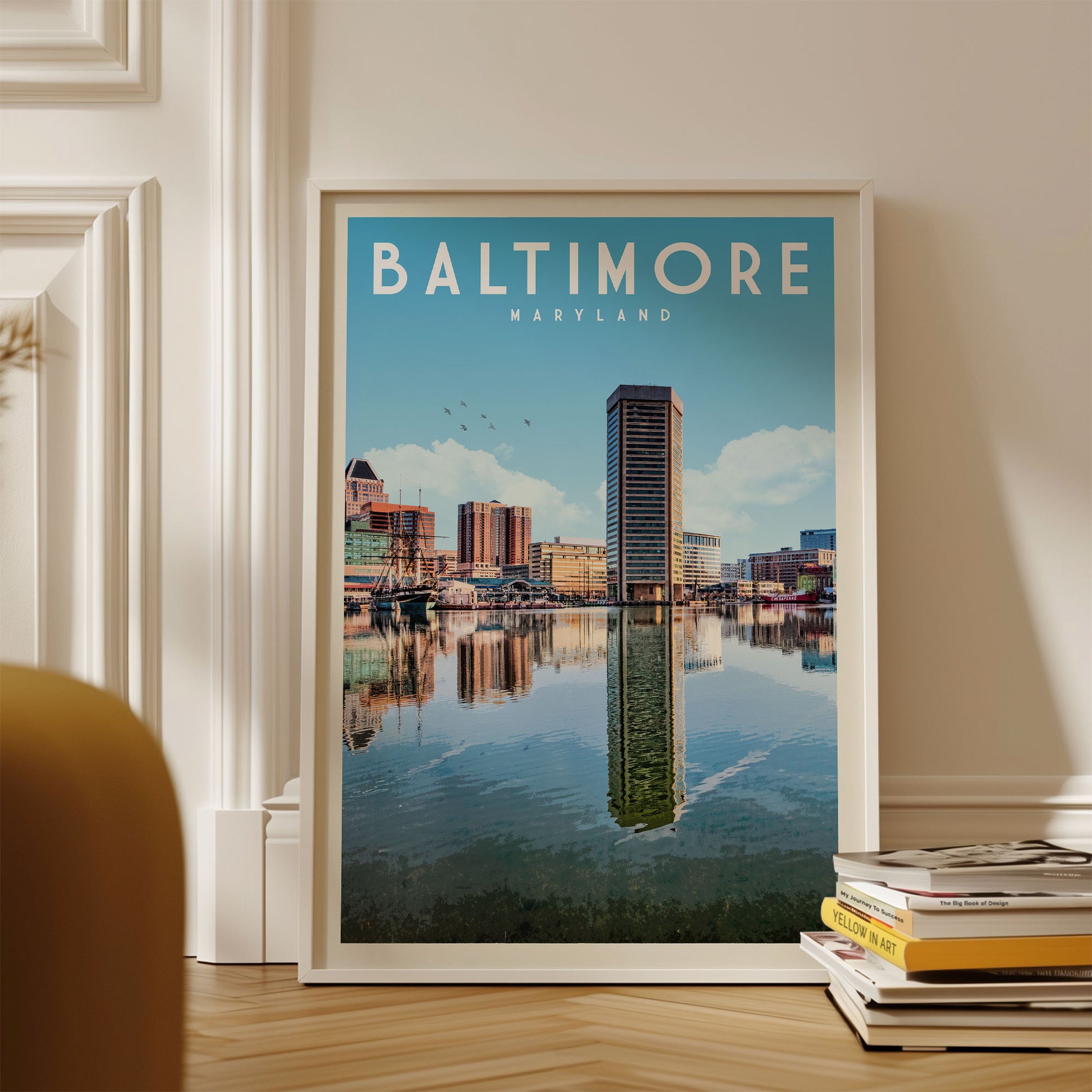A framed poster of the Baltimore skyline, featuring the city's iconic skyline and water reflection, is displayed on a wall.