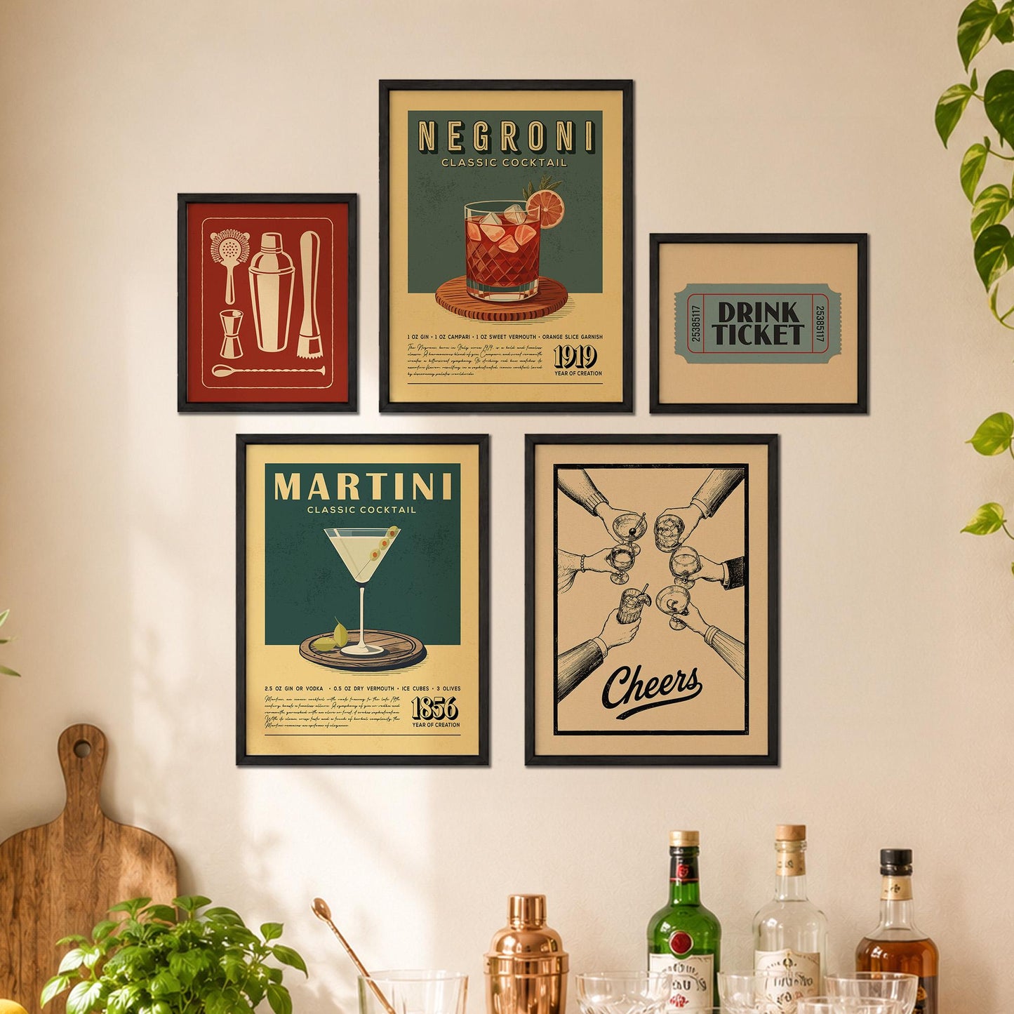 a wall with five framed vintage-style posters or advertisements for different cocktails, including a "NEGRONI Classic Cocktail" and a "DRINK TICKET" poster. There are also several bottles of alcohol displayed on a shelf below the framed posters.