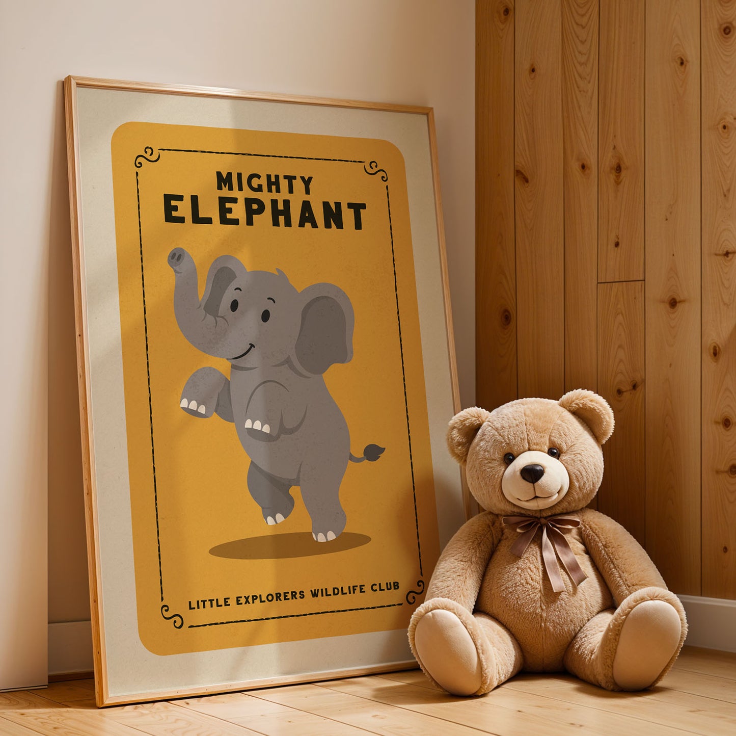 A framed poster of an elephant next to a teddy bear on a wooden floor.