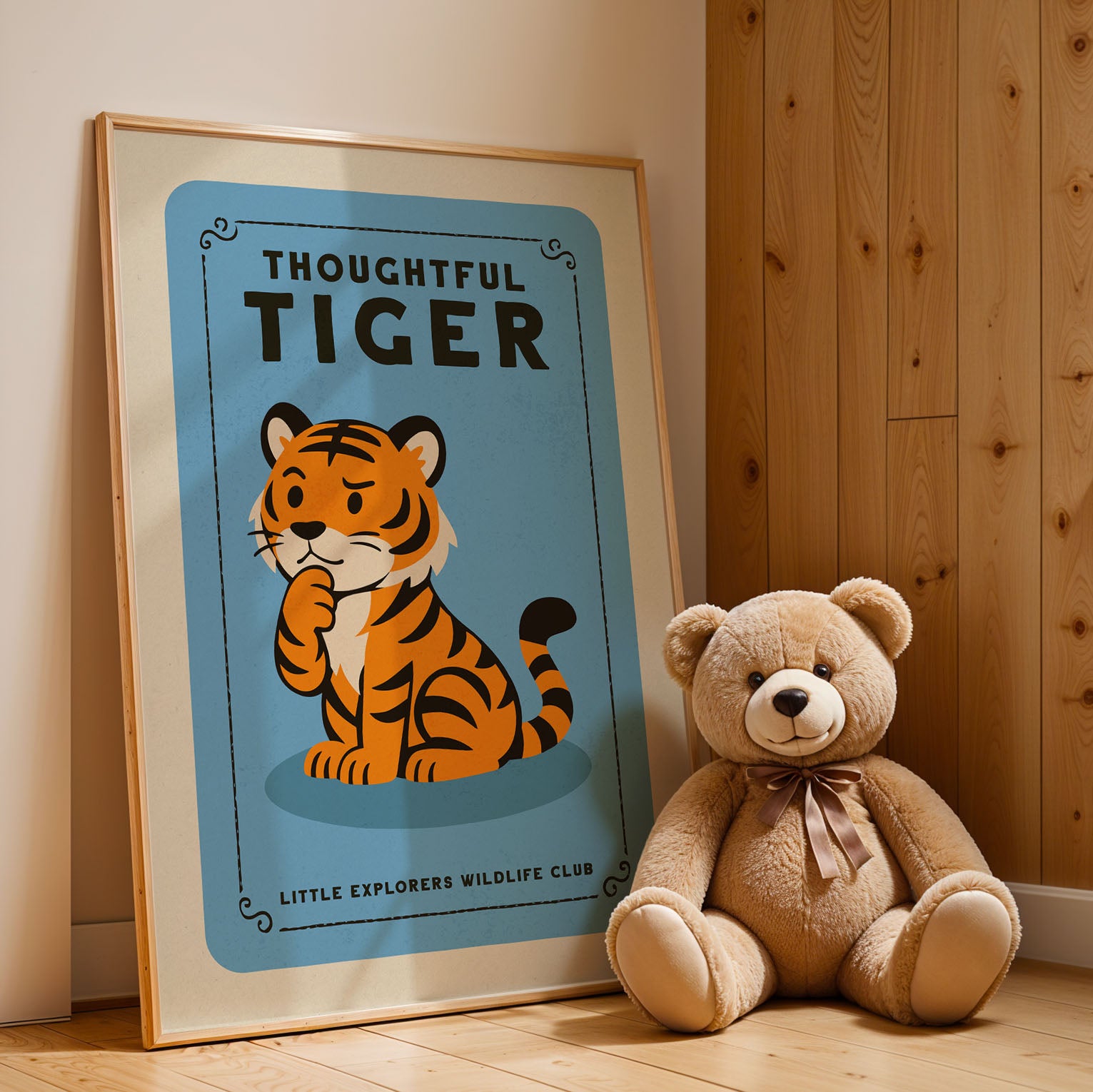 a framed poster of a tiger next to a brown teddy bear, both sitting on a wooden floor.