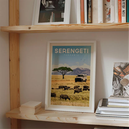 a framed poster of a safari scene in Tanzania, with a truck and a herd of wildebeest in the foreground.